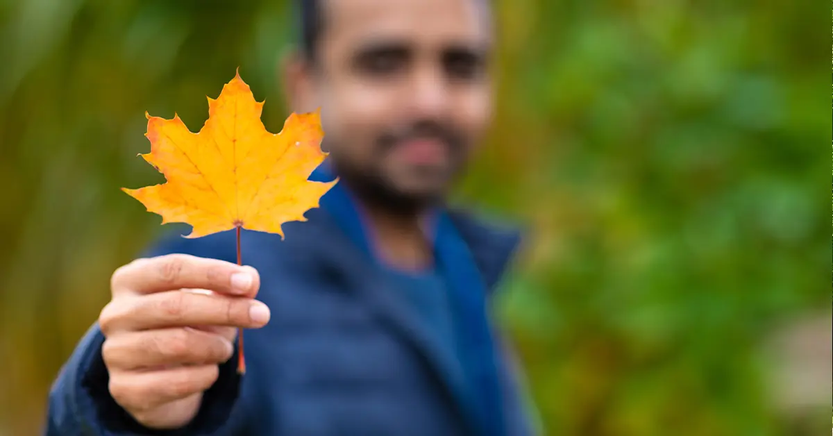Người đàn ông là công dân Canada cầm trên tay lá phong - biểu trưng của đất nước Canada