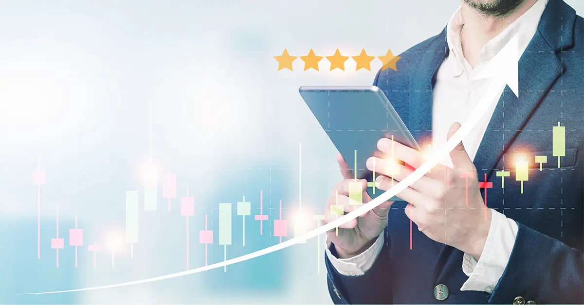 Doanh nhân sử dụng máy tính bảng với cảnh quan thành phố và biểu đồ tài chính trên nền tòa nhà mờ, khái niệm giao dịch kinh doanh