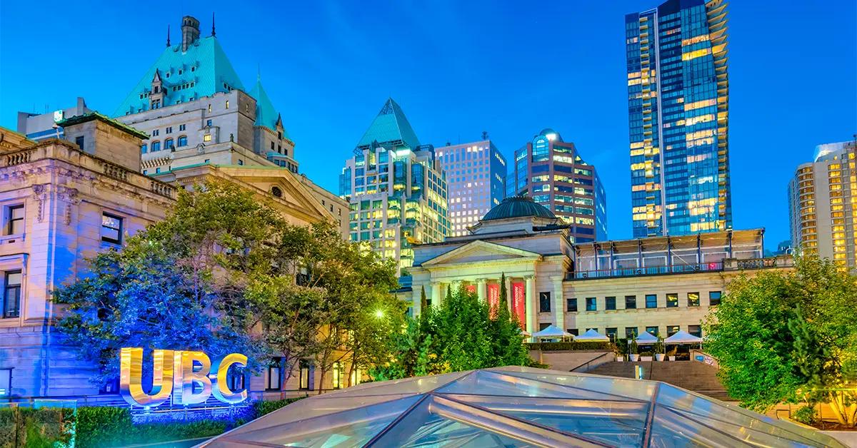 Quảng trường Robson với Phòng trưng bày nghệ thuật Vancouver, Khách sạn Fairmont và các tòa nhà sáng đèn khác ở trung tâm thành phố Vancouver vào ban đêm.